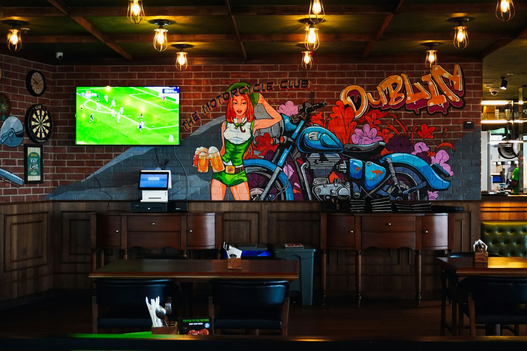 Le bar, ses écrans et sa fresque